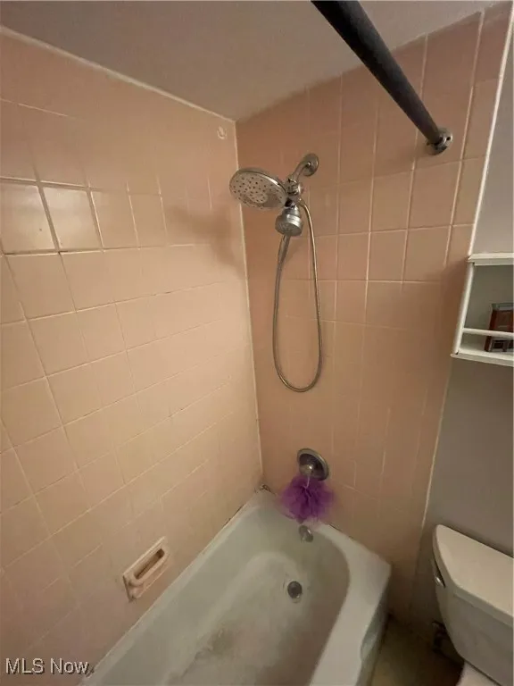 Bathroom featuring shower / tub combination and toilet