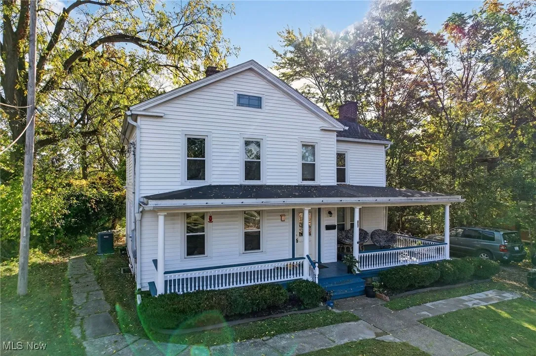 View of front of house featuring covered porch and a chimney