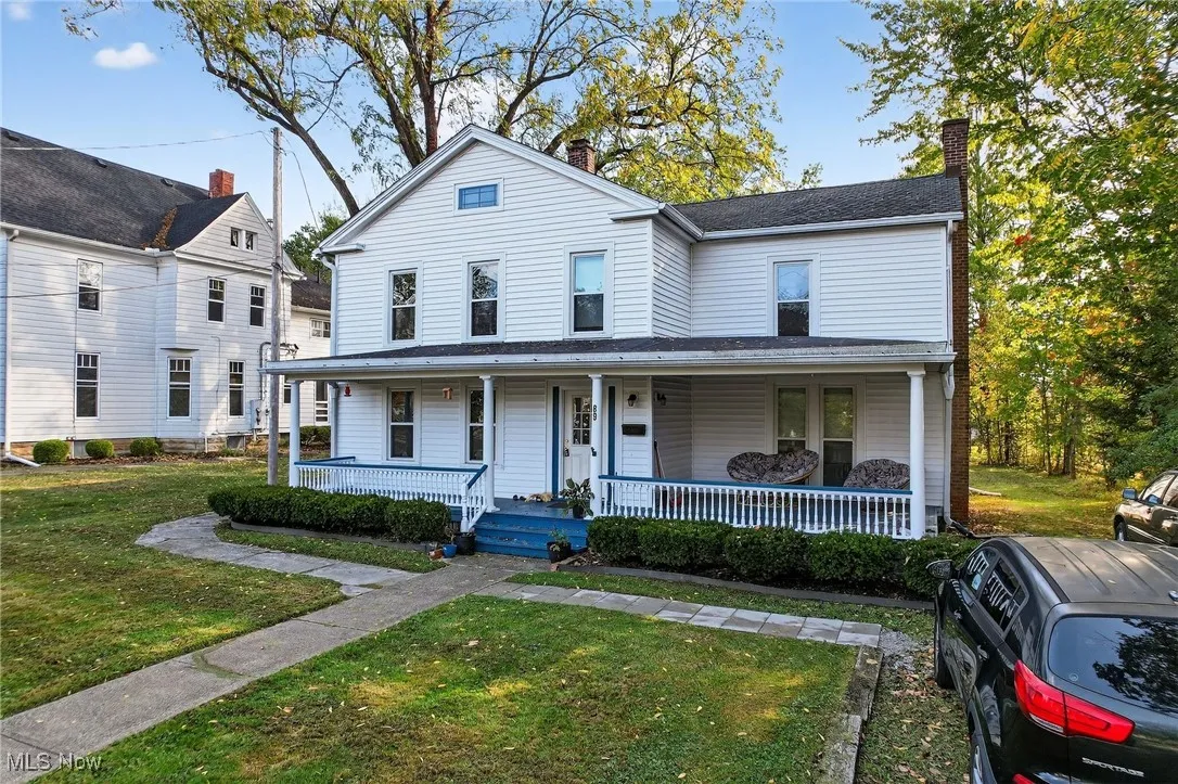 View of front of property featuring a front yard, a porch, and a chimney
