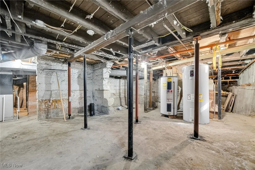 Unfinished basement with electric water heater and heating unit