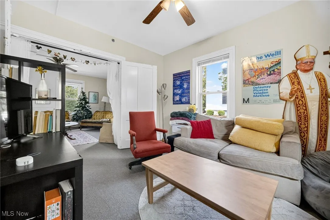Living area with ceiling fan and carpet flooring