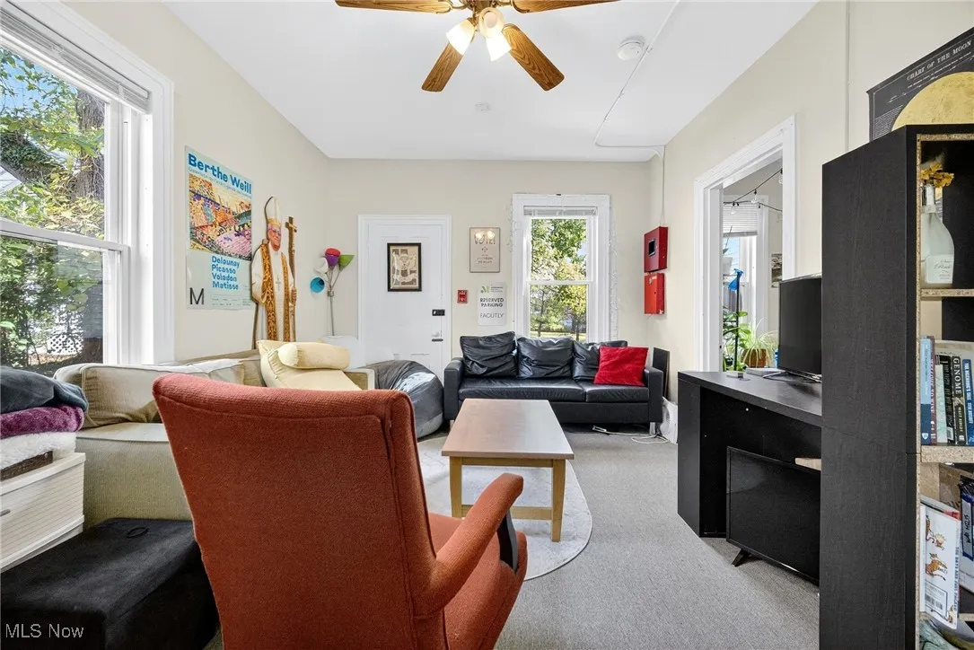 Living room with carpet floors and a ceiling fan