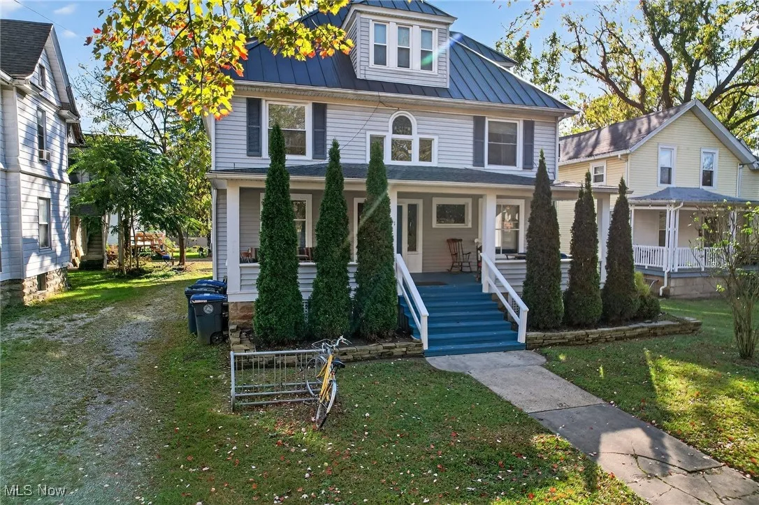 Traditional style home with a porch, a metal roof, a front lawn, and a standing seam roof