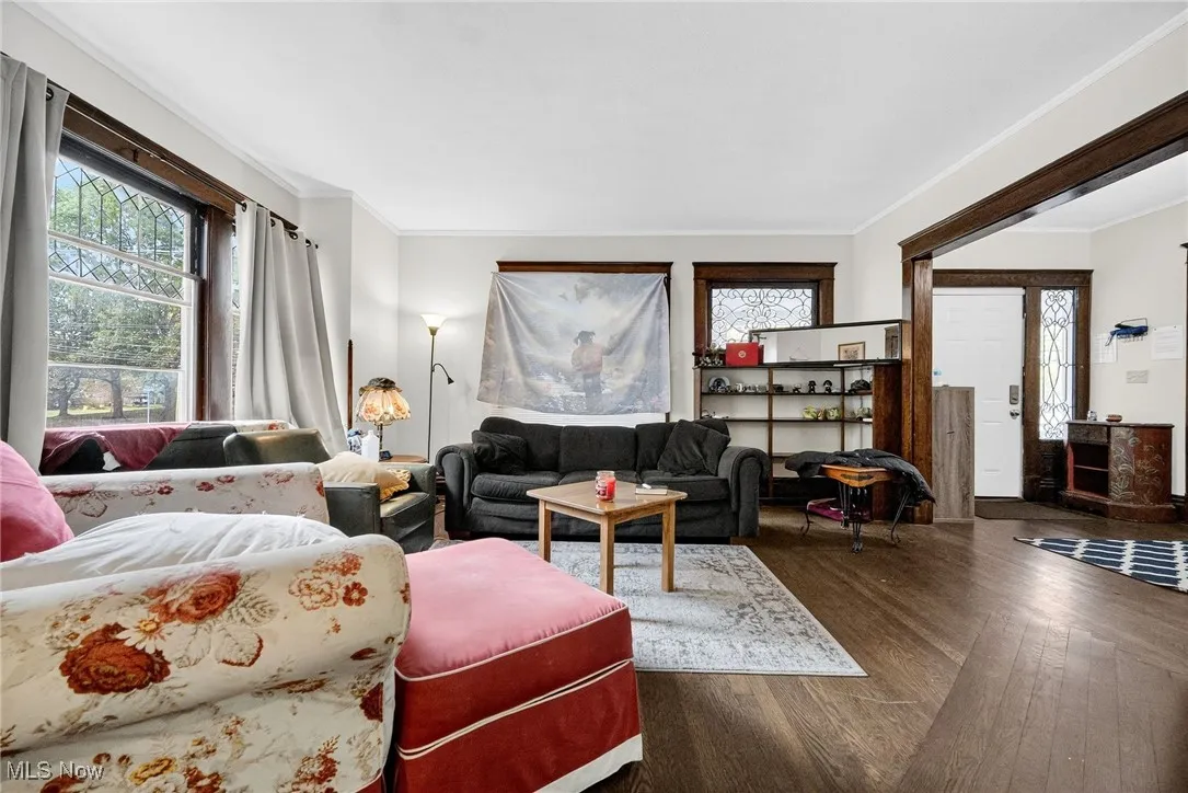 Living room with crown molding and wood finished floors