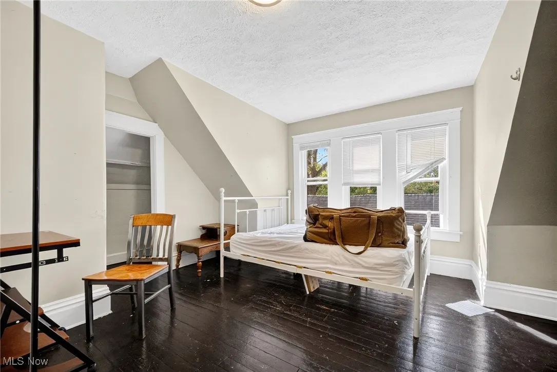 Bedroom with dark wood-type flooring and a textured ceiling