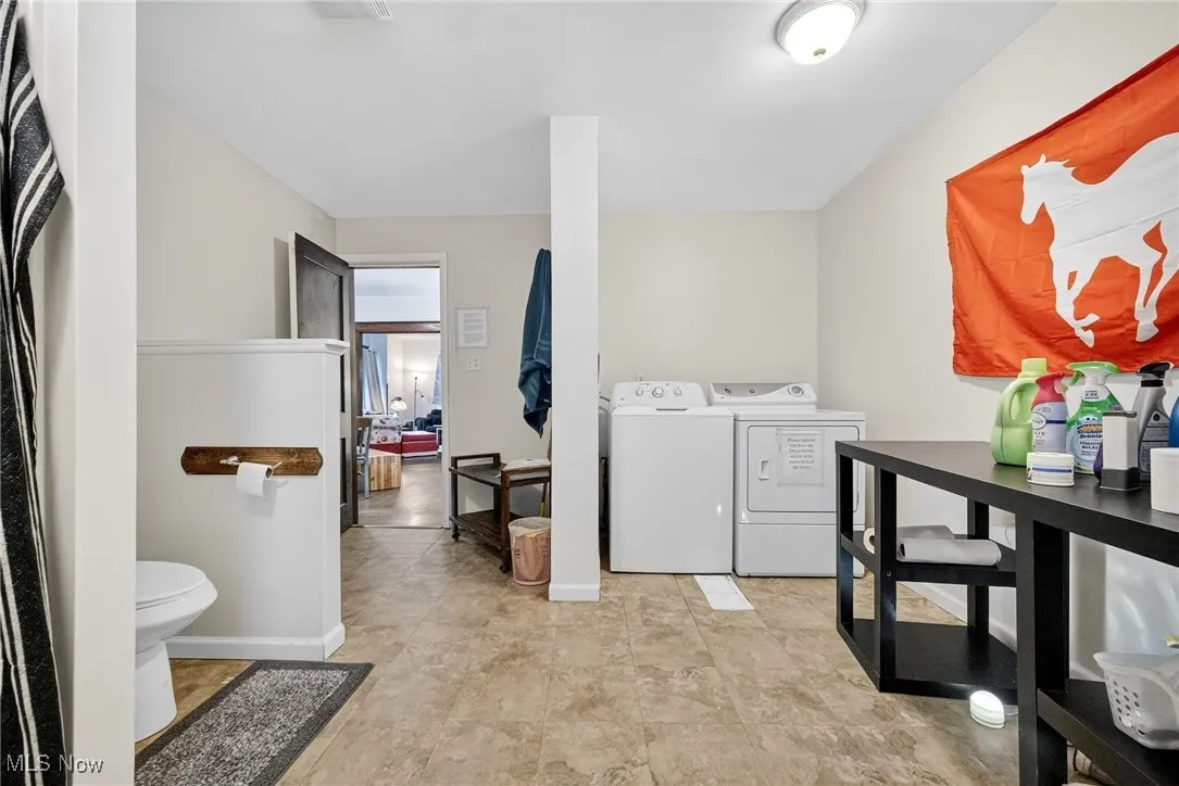 Laundry area with washer and clothes dryer and baseboards