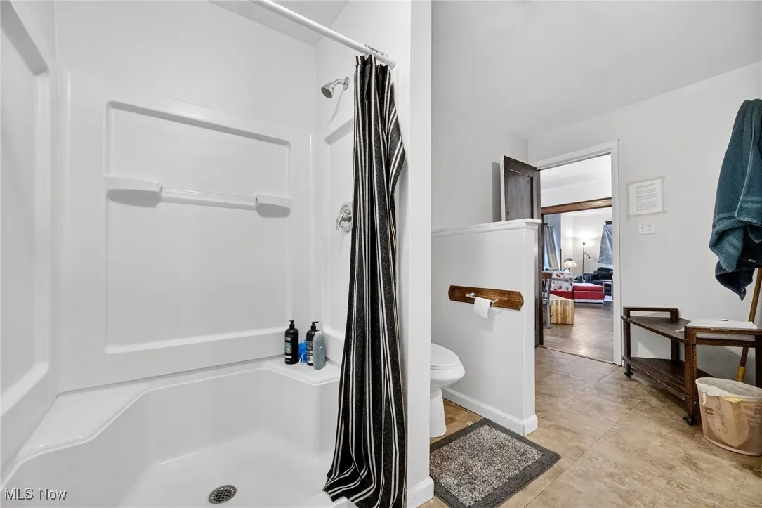 Bathroom with a shower stall and toilet