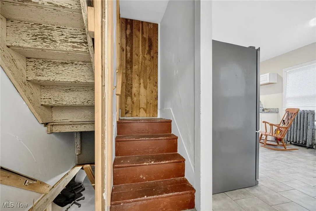 Stairway with tile patterned floors and radiator