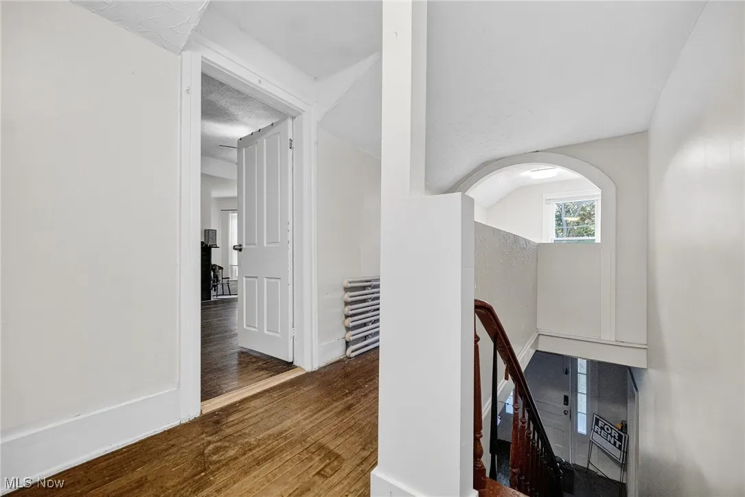 Hall featuring an upstairs landing and wood finished floors