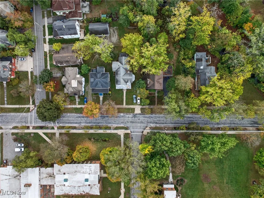 Aerial view of property and surrounding area featuring nearby suburban area
