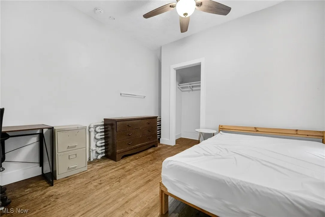 Bedroom featuring light wood-type flooring, a closet, and a ceiling fan