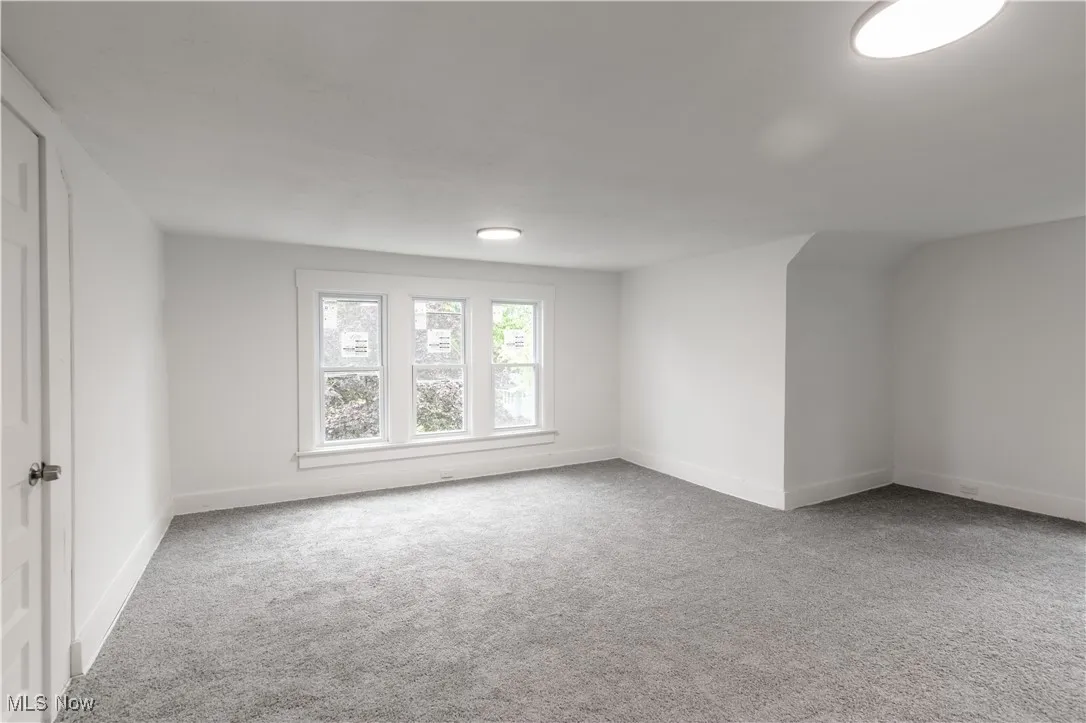Empty room featuring light colored carpet and baseboards