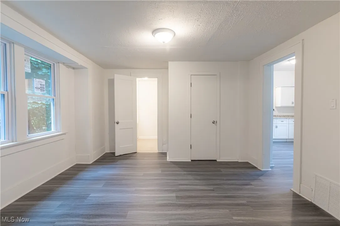 Unfurnished bedroom featuring a textured ceiling and dark wood-style floors