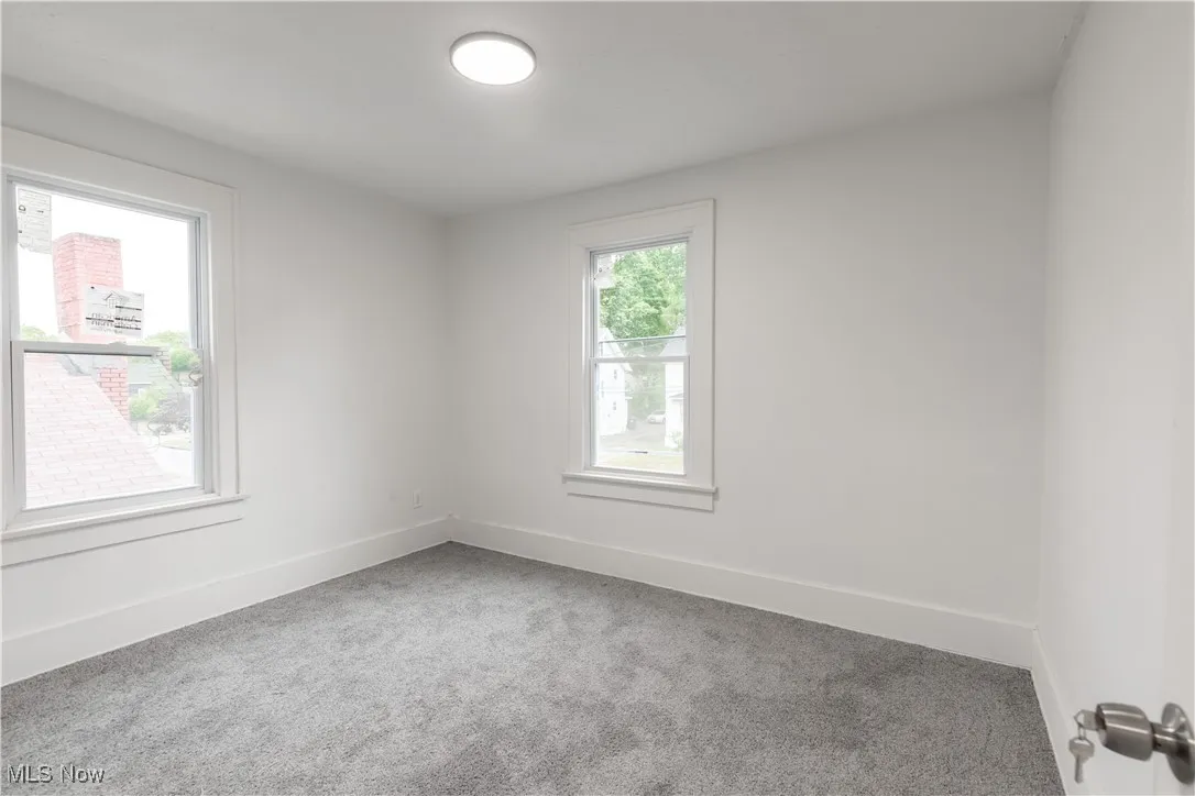 Carpeted empty room featuring baseboards