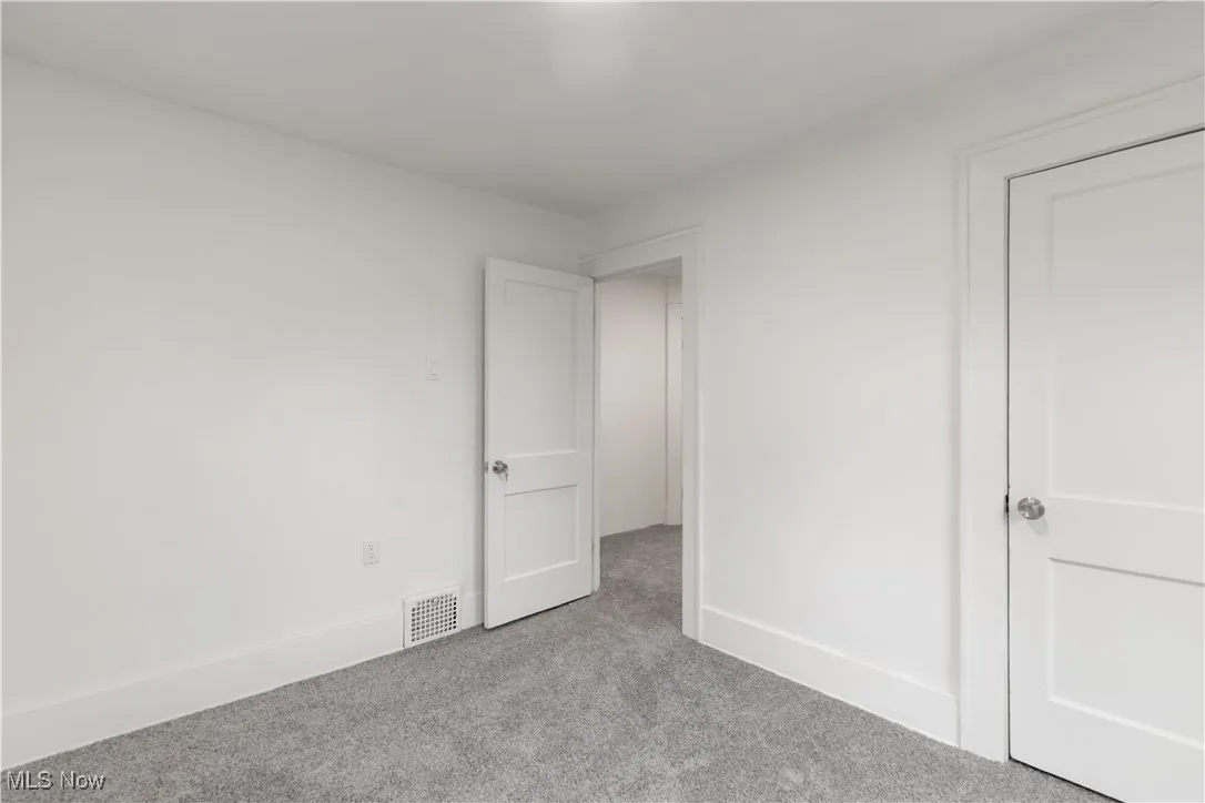 Unfurnished bedroom with carpet flooring and baseboards