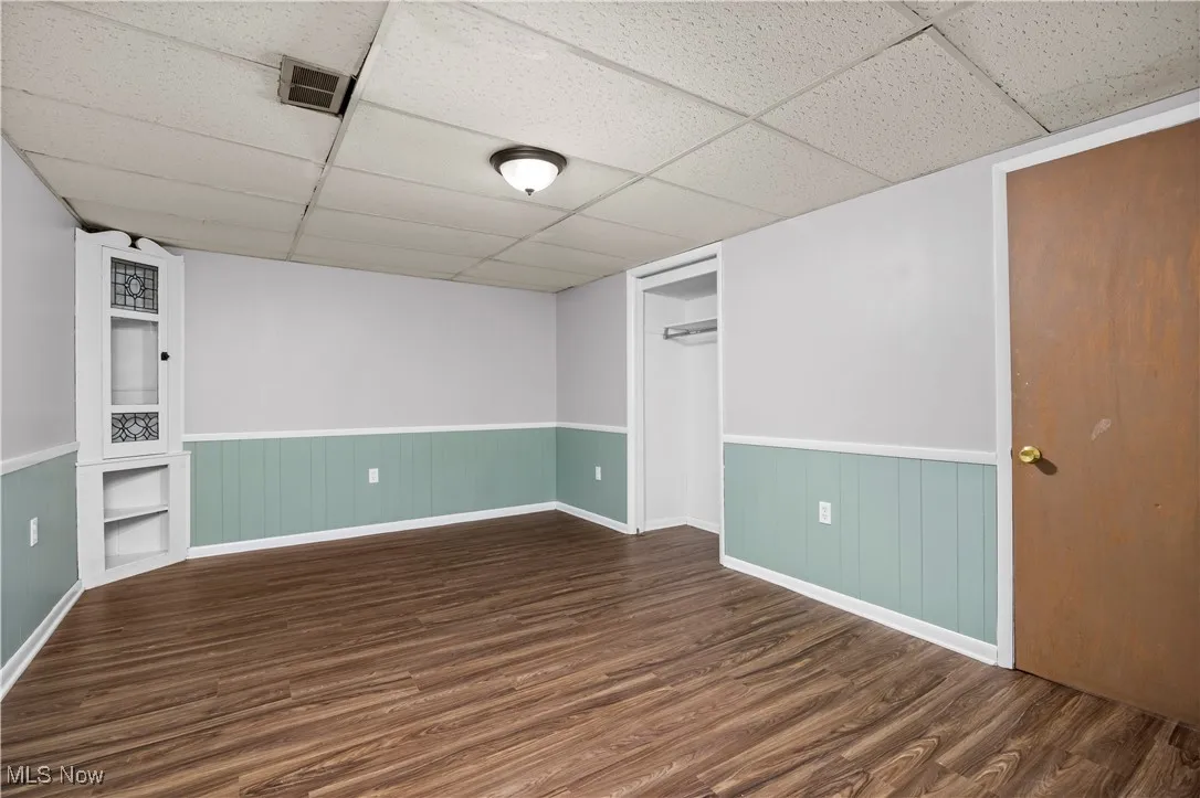 Finished below grade area featuring dark wood finished floors and a paneled ceiling