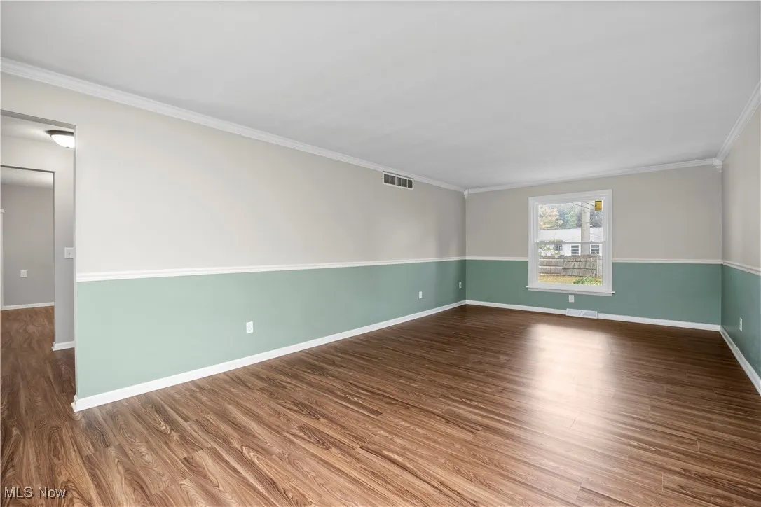 Unfurnished room with dark wood finished floors and crown molding
