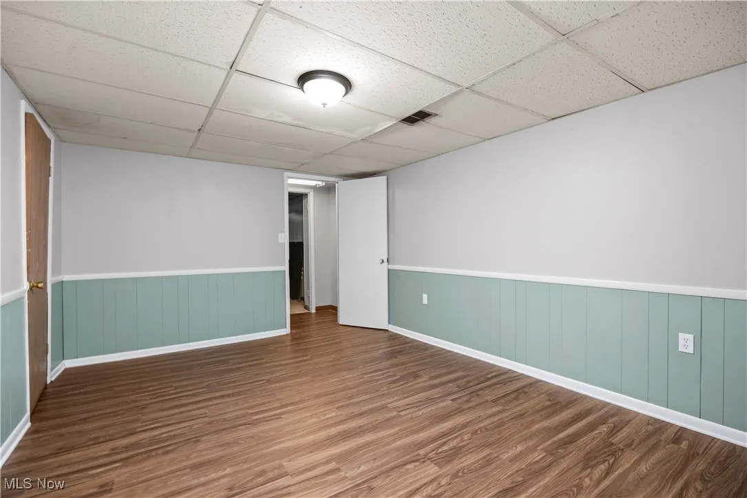 Spare room with wood finished floors and a paneled ceiling