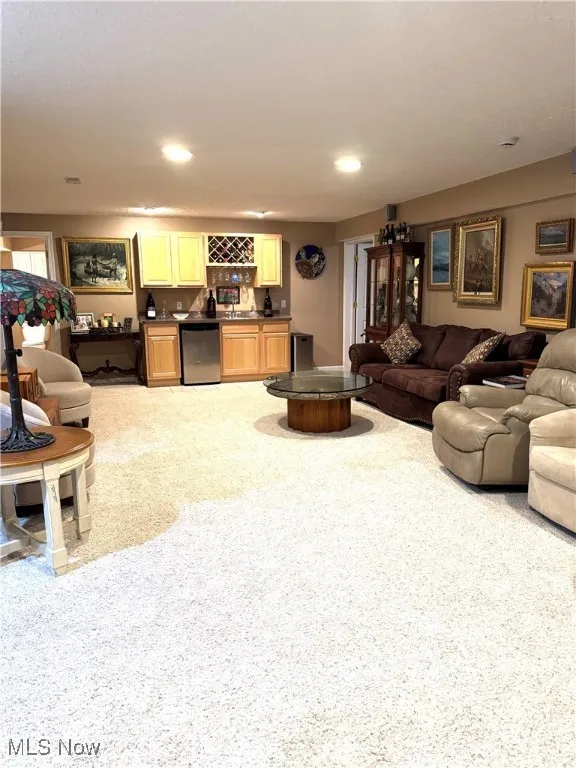 Living area with bar with sink and recessed lighting