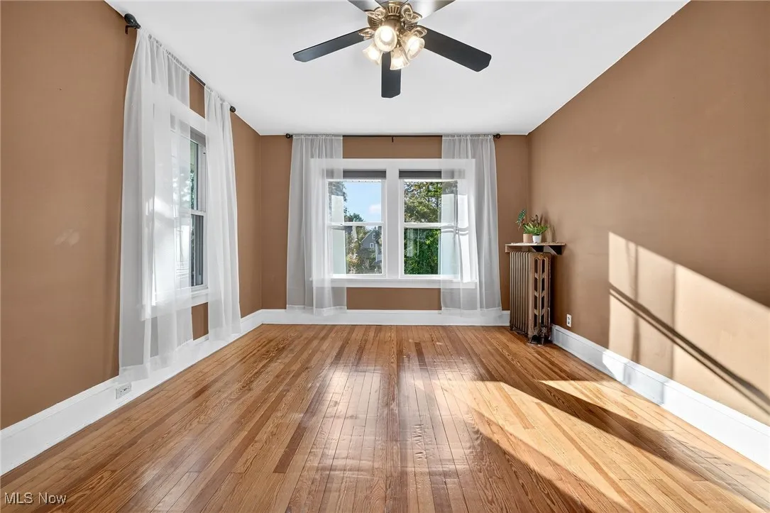 Unfurnished room featuring wood-type flooring and radiator heating unit