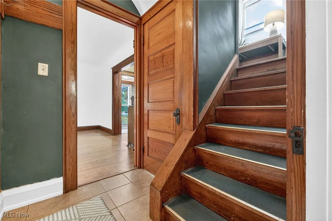 Staircase with baseboards and tile patterned floors