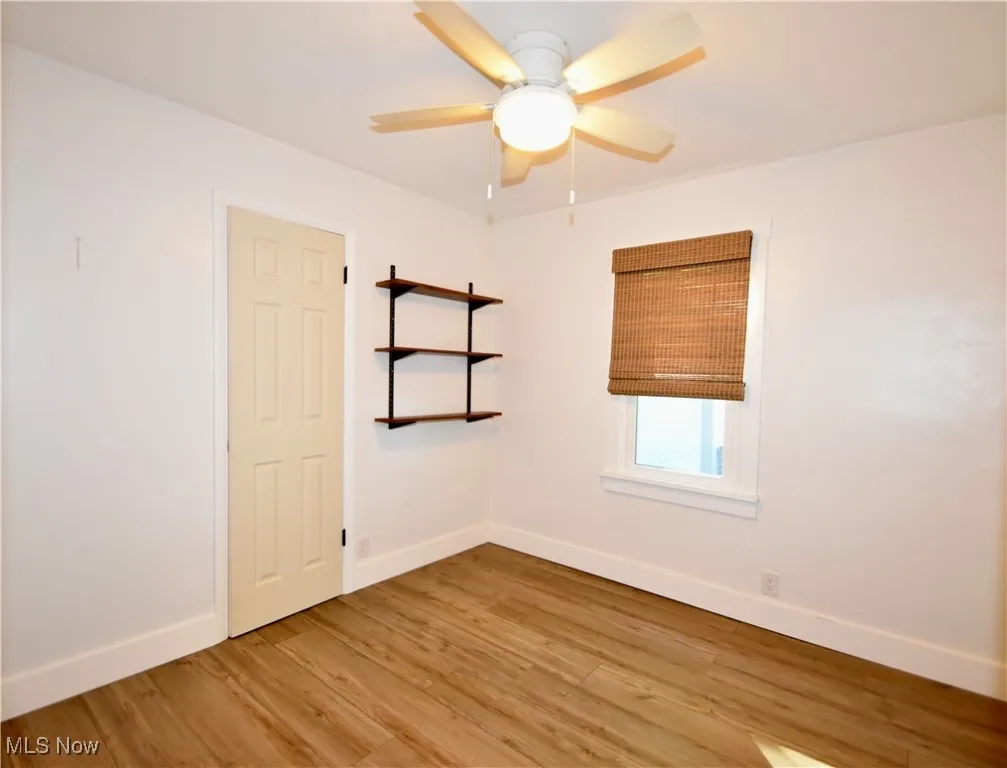Spare room featuring light wood-type flooring and ceiling fan