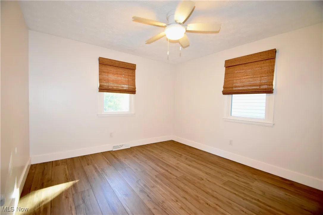 Spare room with light wood-type flooring and ceiling fan