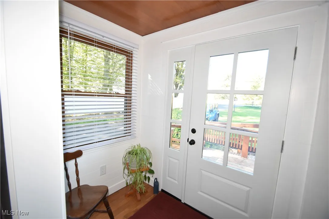 Doorway with healthy amount of natural light and wood finished floors