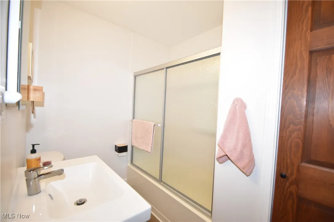 Bathroom with enclosed tub / shower combo