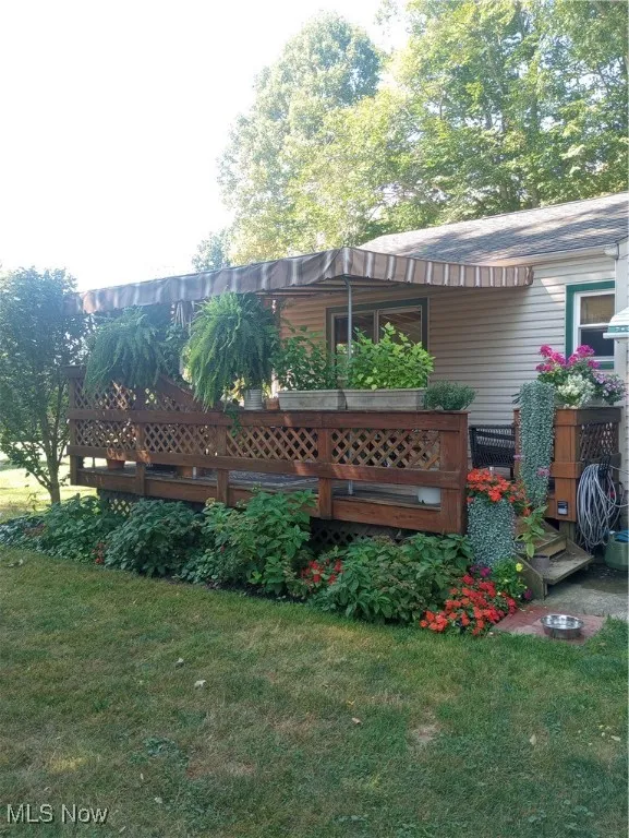 View of grassy yard featuring a wooden deck