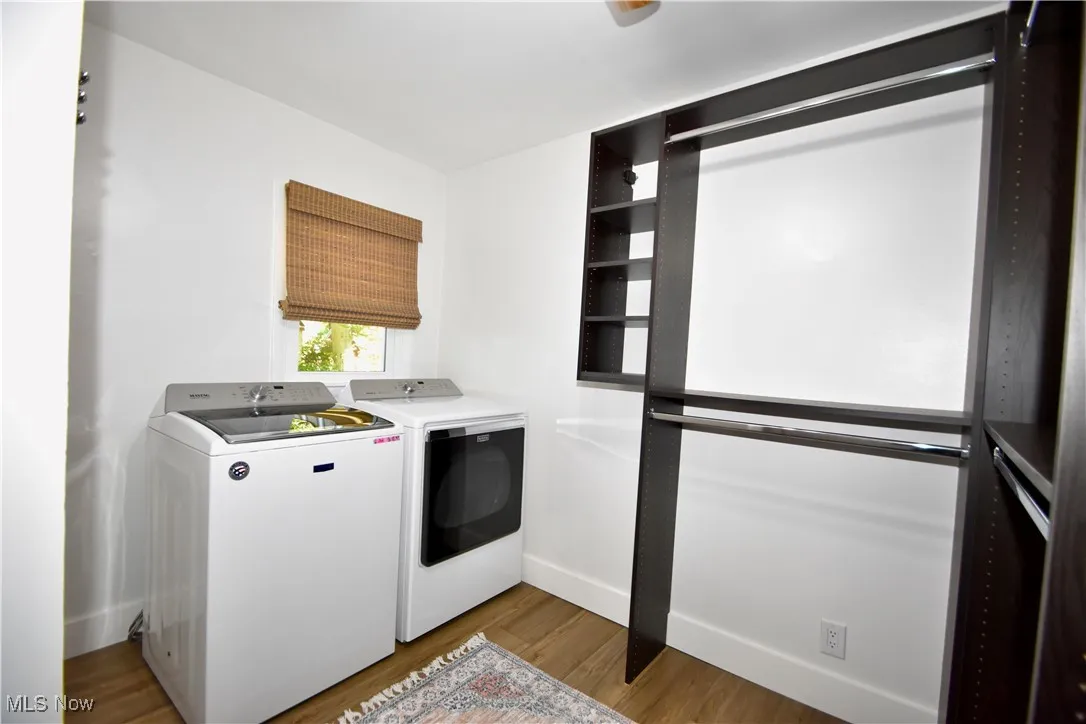 Washroom featuring light wood-style floors and washer and clothes dryer
