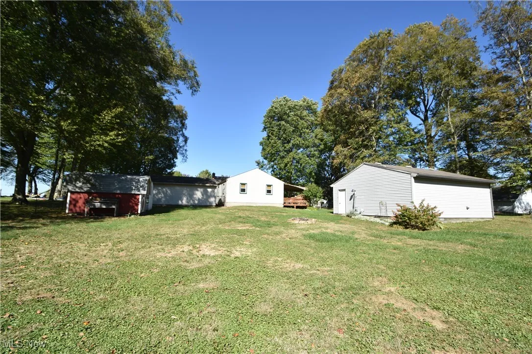 View of green lawn featuring an outbuilding