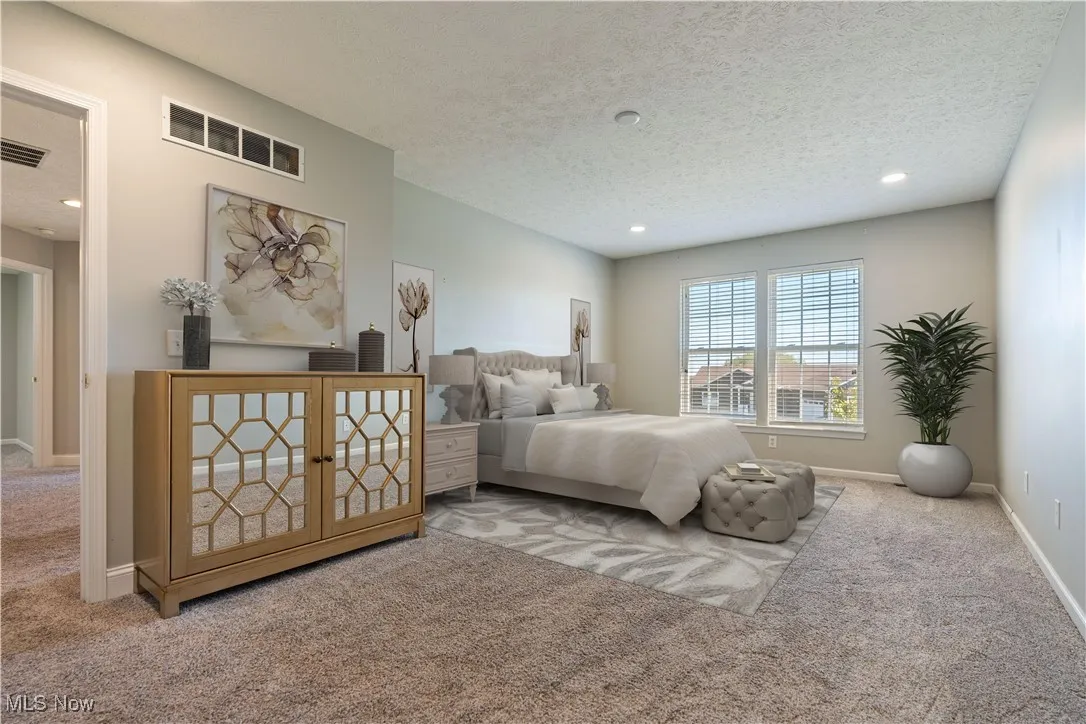 Bedroom featuring light carpet, a textured ceiling, and recessed lighting