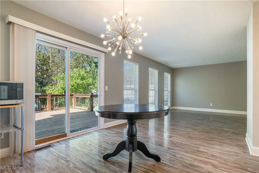 Unfurnished dining area with wood finished floors and a chandelier