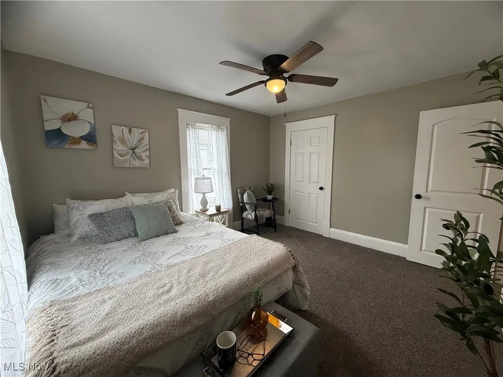 Carpeted bedroom featuring baseboards and ceiling fan