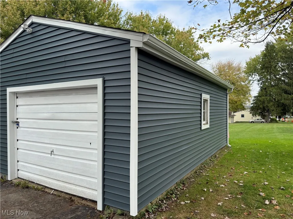 View of home's exterior with an outbuilding and a lawn