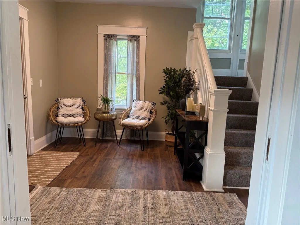 Living area featuring stairway and dark wood finished floors