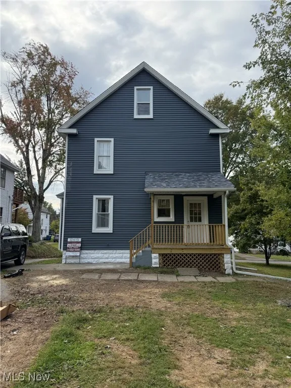 View of front of property featuring a porch and a front yard