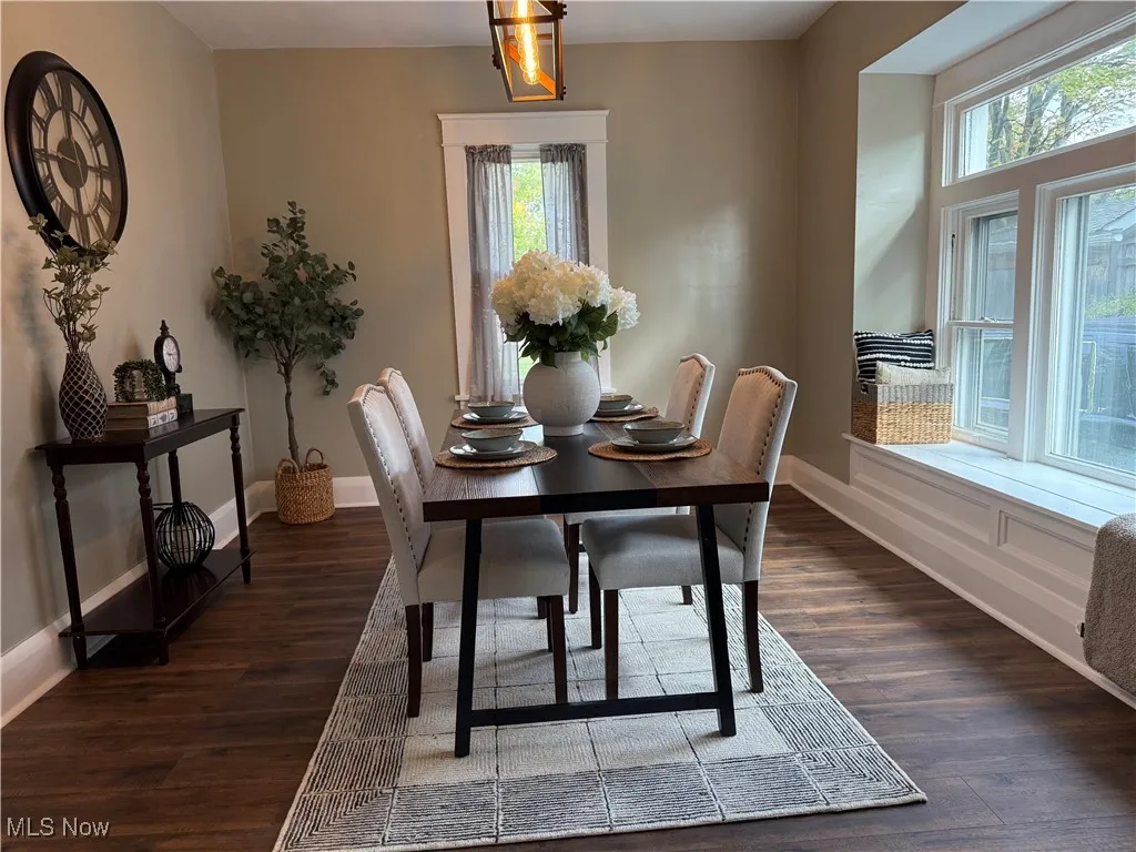 Dining room with dark wood-style flooring and baseboards