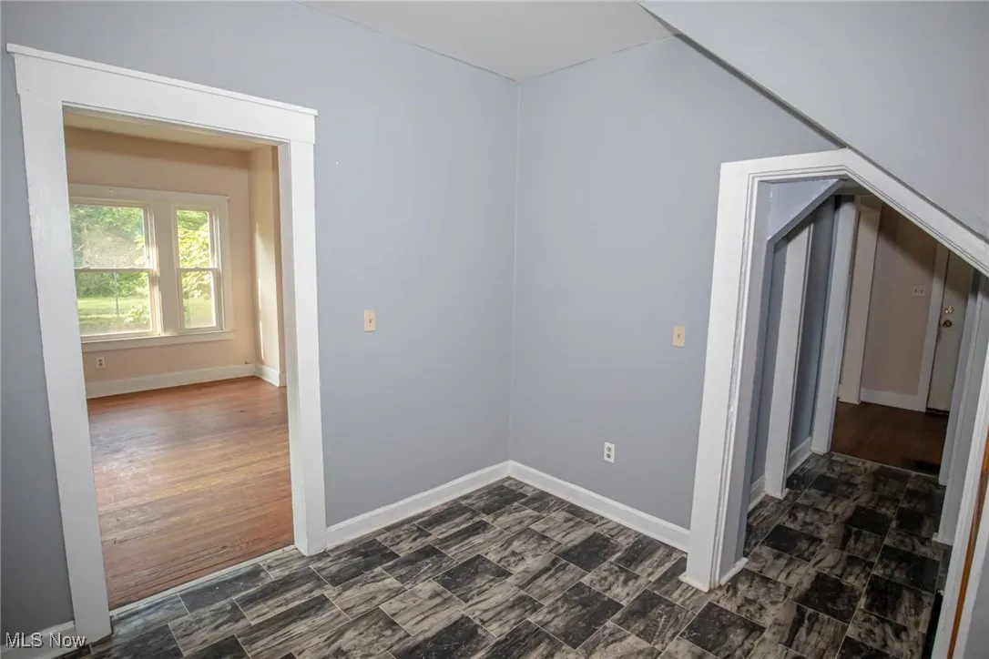 Bonus room featuring baseboards and dark wood finished floors