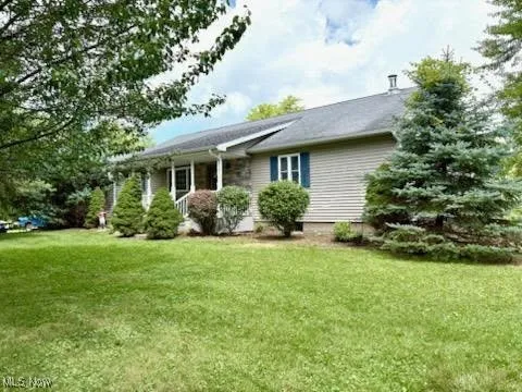 Back of house with a lawn and a porch