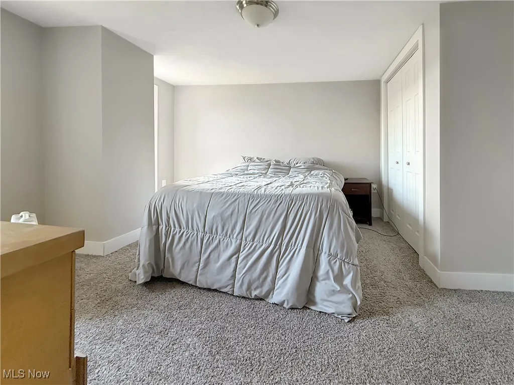 Bedroom featuring light colored carpet and a closet