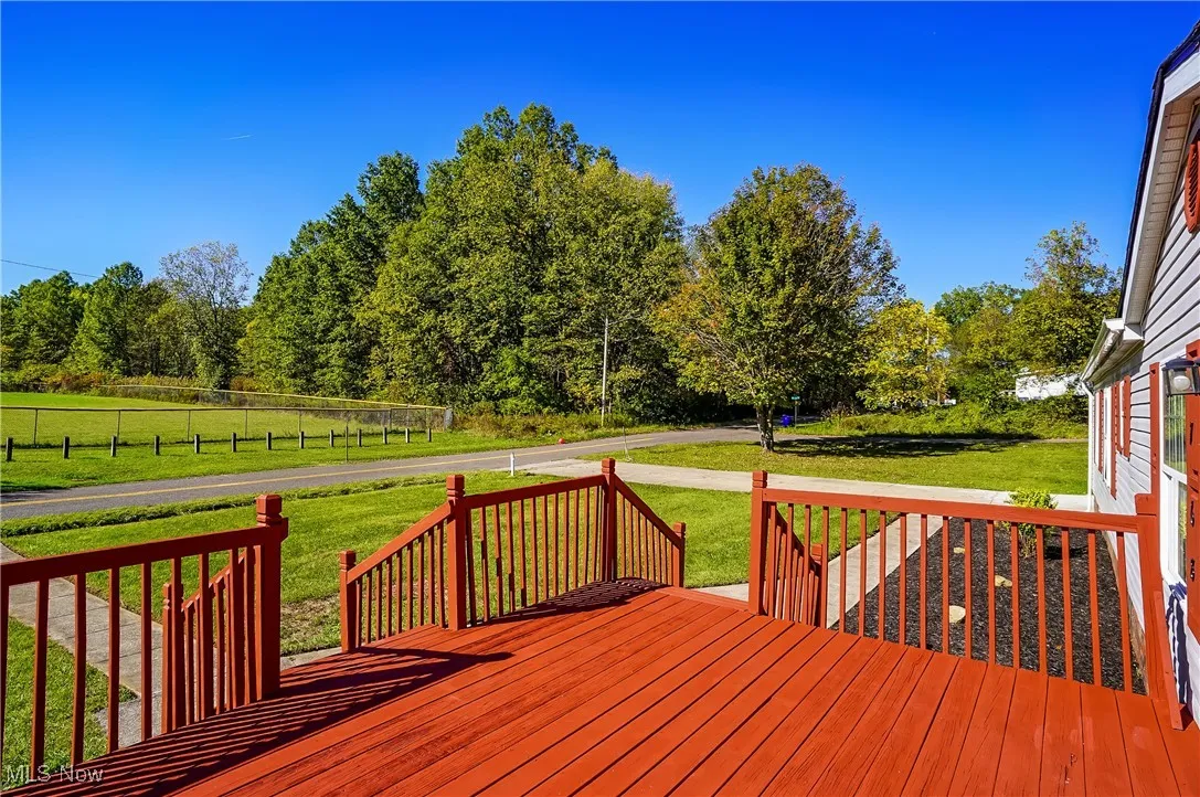 Another view of the front deck. Large concrete driveway provides plenty of parking space.