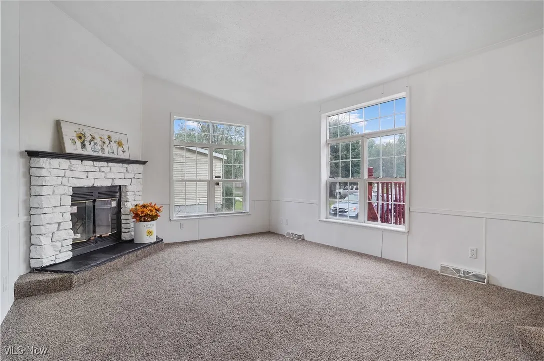 Living room features a lovely fireplace. New 2025 paint and blinds. 2024 new carpet was installed.