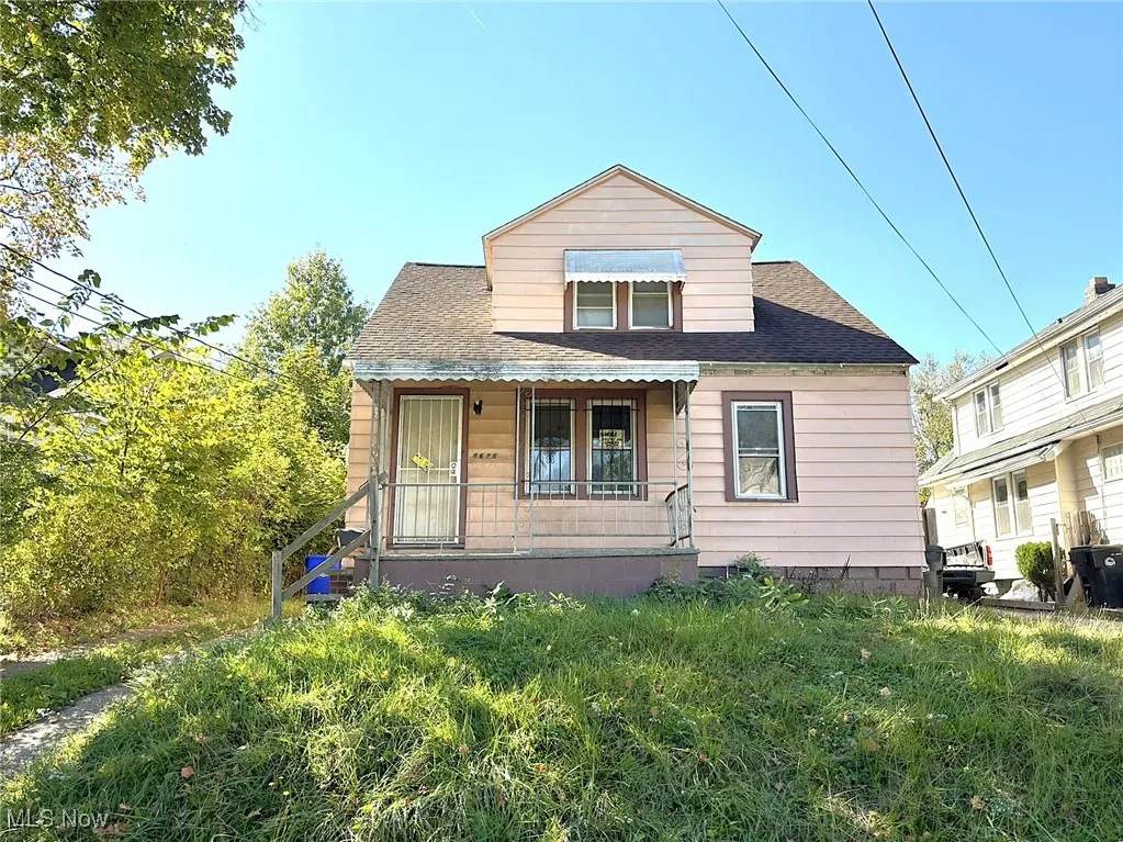 Rear view of house featuring a porch and a shingled roof