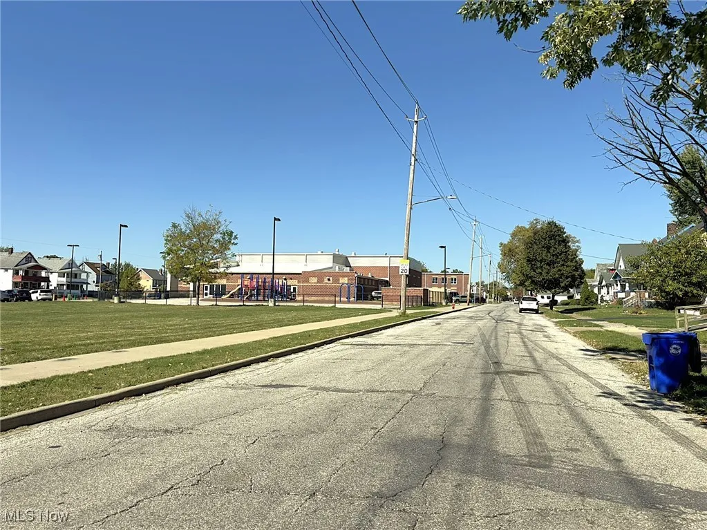 View of asphalt street with a residential view, sidewalks, street lighting, and curbs