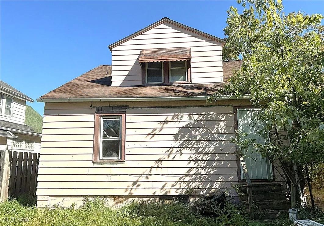 View of side of home featuring roof with shingles