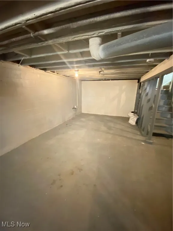 Unfinished below grade area featuring stairway