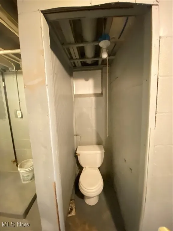 Bathroom featuring toilet and concrete floors