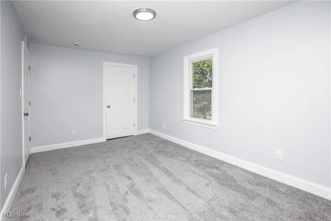 Carpeted spare room with baseboards
